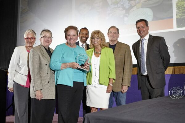 carol simler holding an award