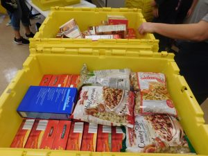 Bins from Villa Park Office Equipment filled with non-perishable food items and paper products.