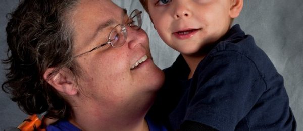 a kid cropped being held by a parent