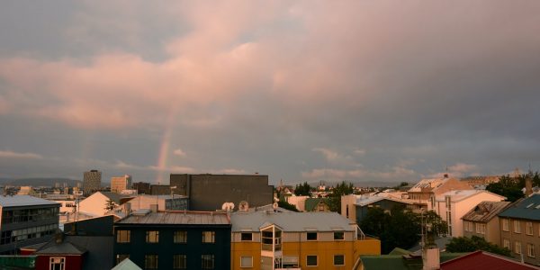 Small town under cloudy sky and rainbow